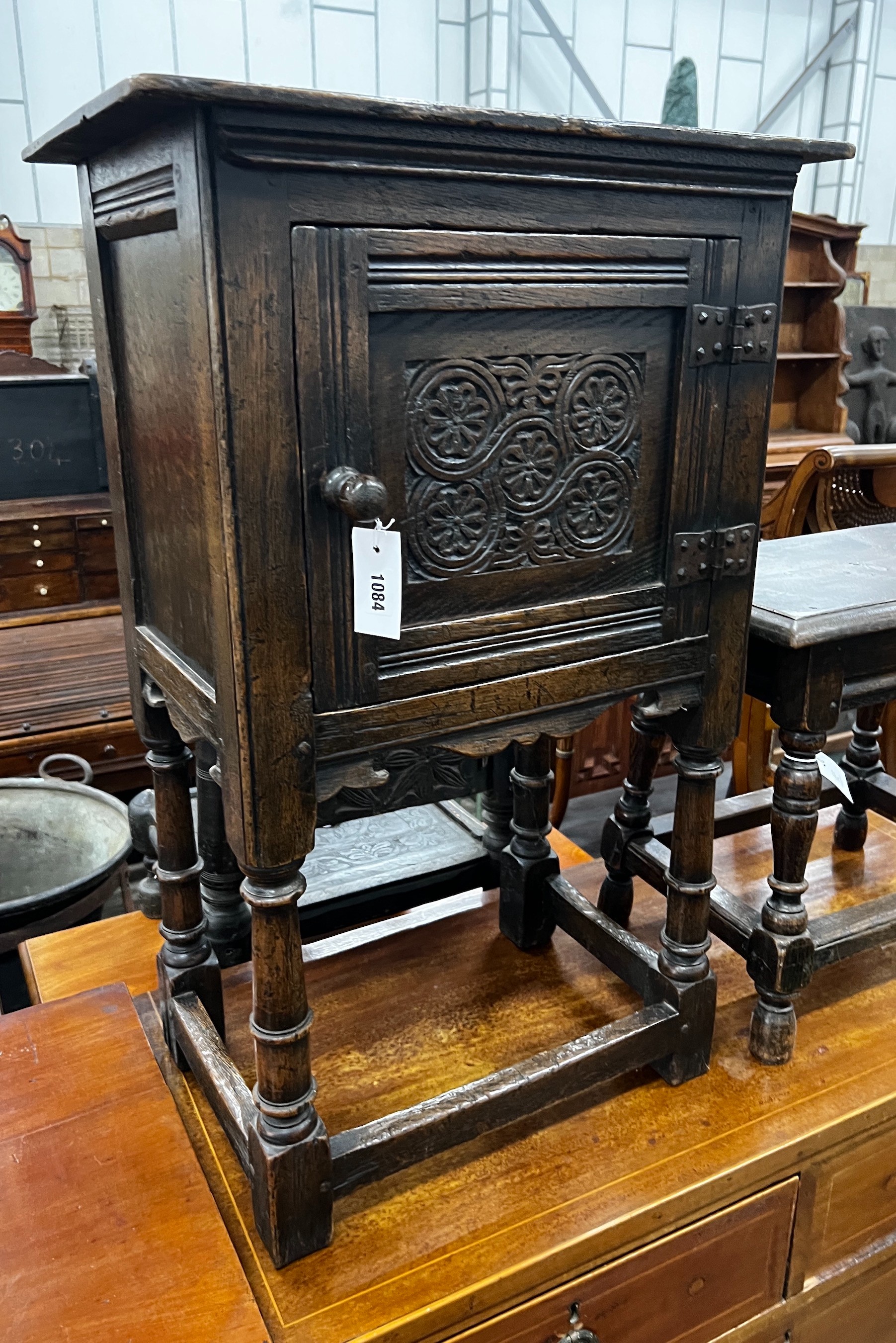 A small 17th century style carved oak side cabinet, width 53cm, depth 34cm, height 83cm